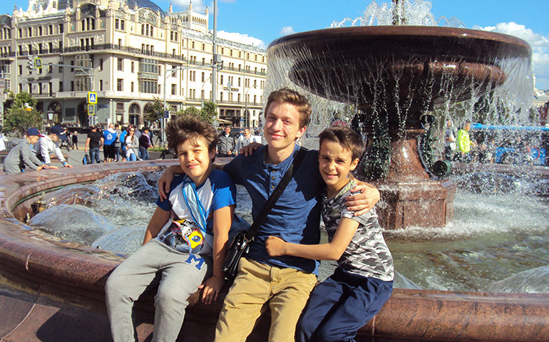 Greenheart Traveler with host siblings in front of a fountain in Russia.